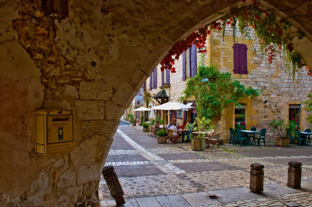 Monpazier — la place de la bastide vue sous une arcade des cornières