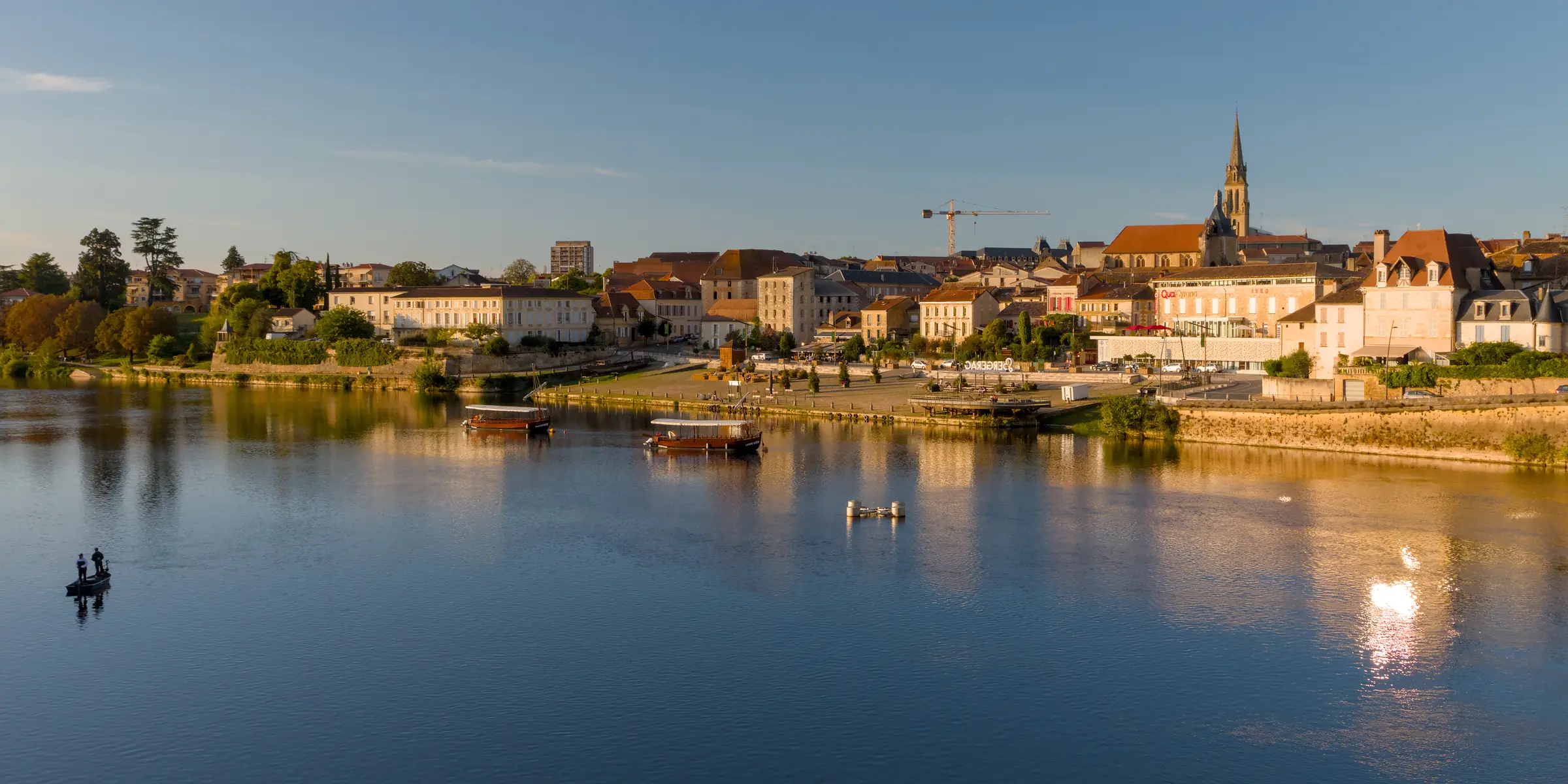 Bergerac — La vieille ville et le clocher de Notre-Dame au-dessus de la Dordogne, en lumière de fin d'après-midi.