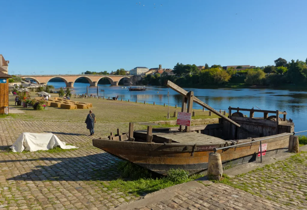 Bergerac — Une gabare sur le quai Salvette, l'ancien port, avec le vieux pont en arrière-plan.