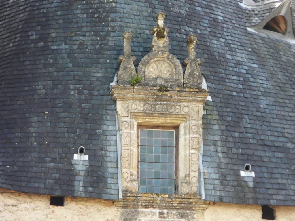 Château de Jumilhac — une lucarne Renaissance ouvragée sur les toits d'ardoise