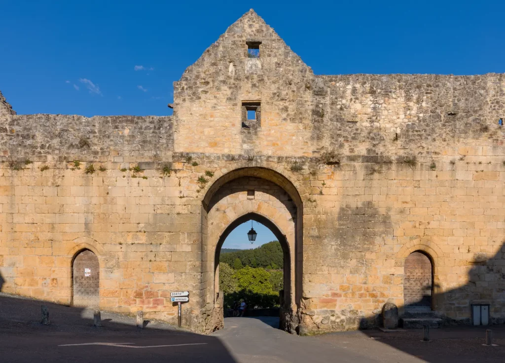 Domme — La porte des Tours, porte fortifiée de la bastide, côté intérieur, dans la lumière de fin de journée.