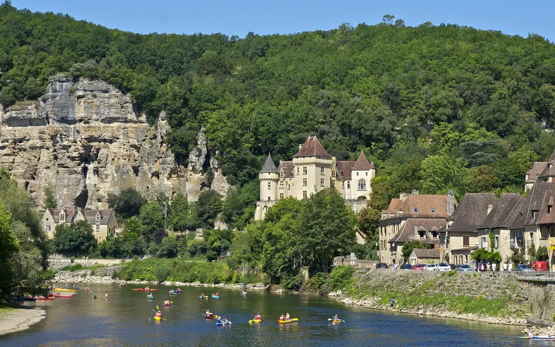 La Roque-Gageac — La falaise, le manoir de la Malartrie et les maisons du village au bord de la Dordogne, canoës sur l'e