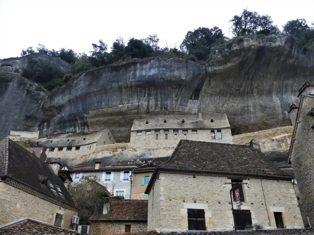 Les Eyzies — le bourg des Eyzies blotti sous la grande falaise en surplomb