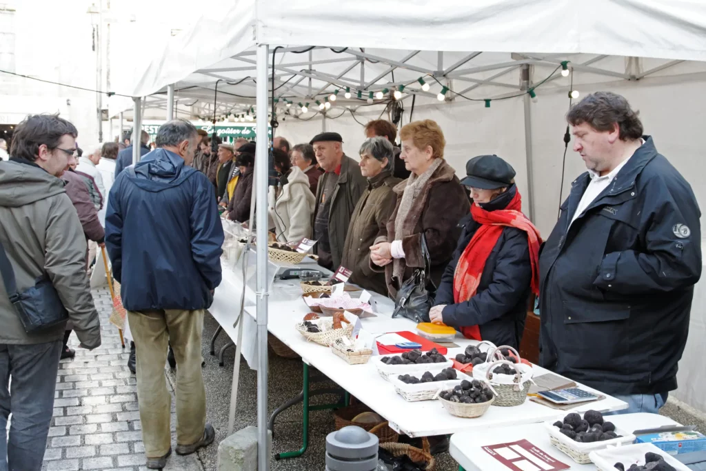 Acheteurs devant les stands du marché aux truffes de Périgueux