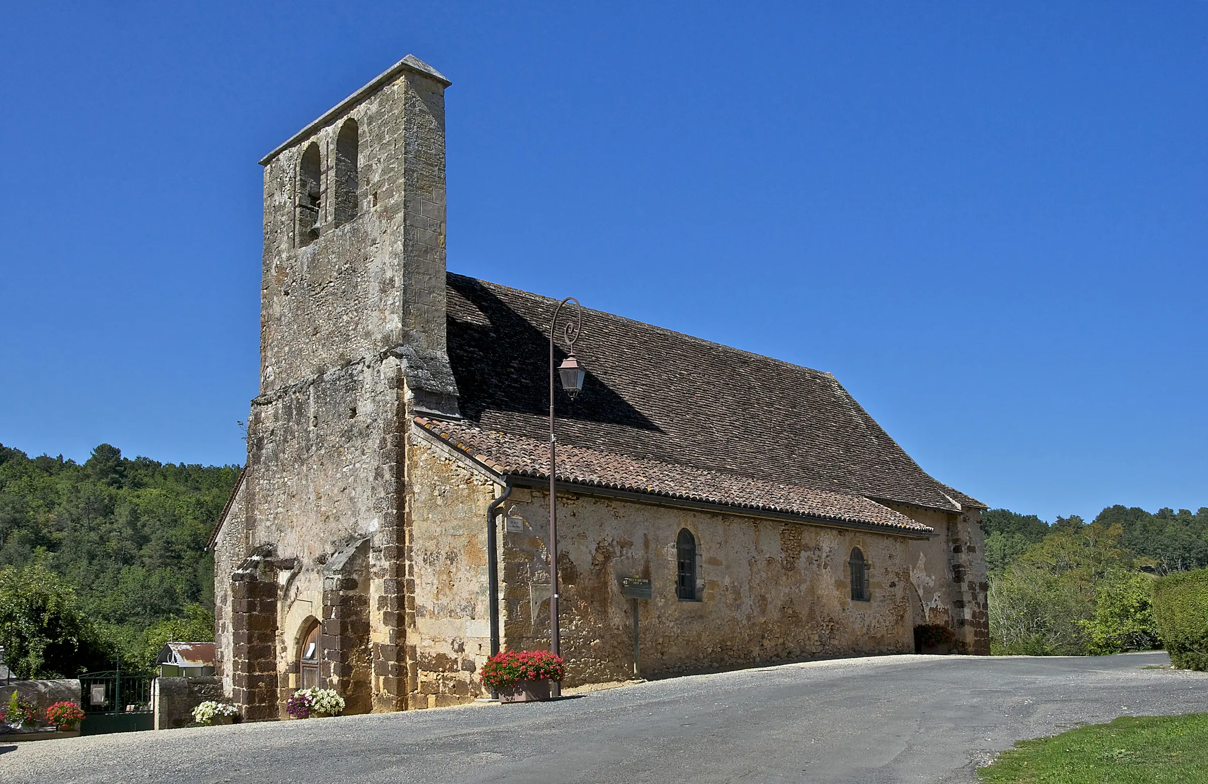 Rouffignac-Saint-Cernin-de-Reilhac — église romane Saint-Saturnin de Saint-Cernin-de-Reilhac sous ciel bleu