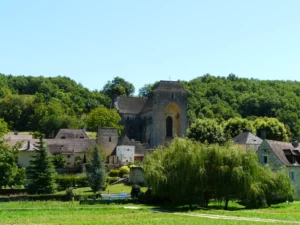 Saint-Amand-de-Coly — le village et son abbatiale fortifiée derrière les saules
