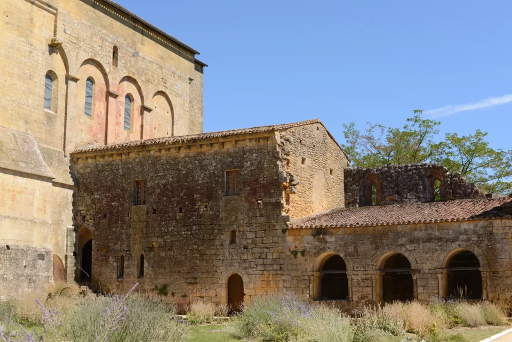 Saint-Avit-Sénieur — bâtiments conventuels et arcades du prieuré au pied de l'église