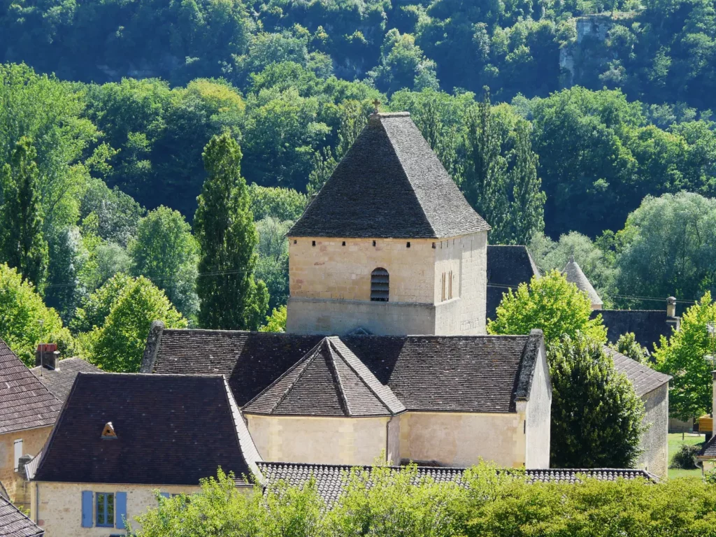 Tursac — église romane fortifiée Saint-Julien au milieu des toits et de la verdure