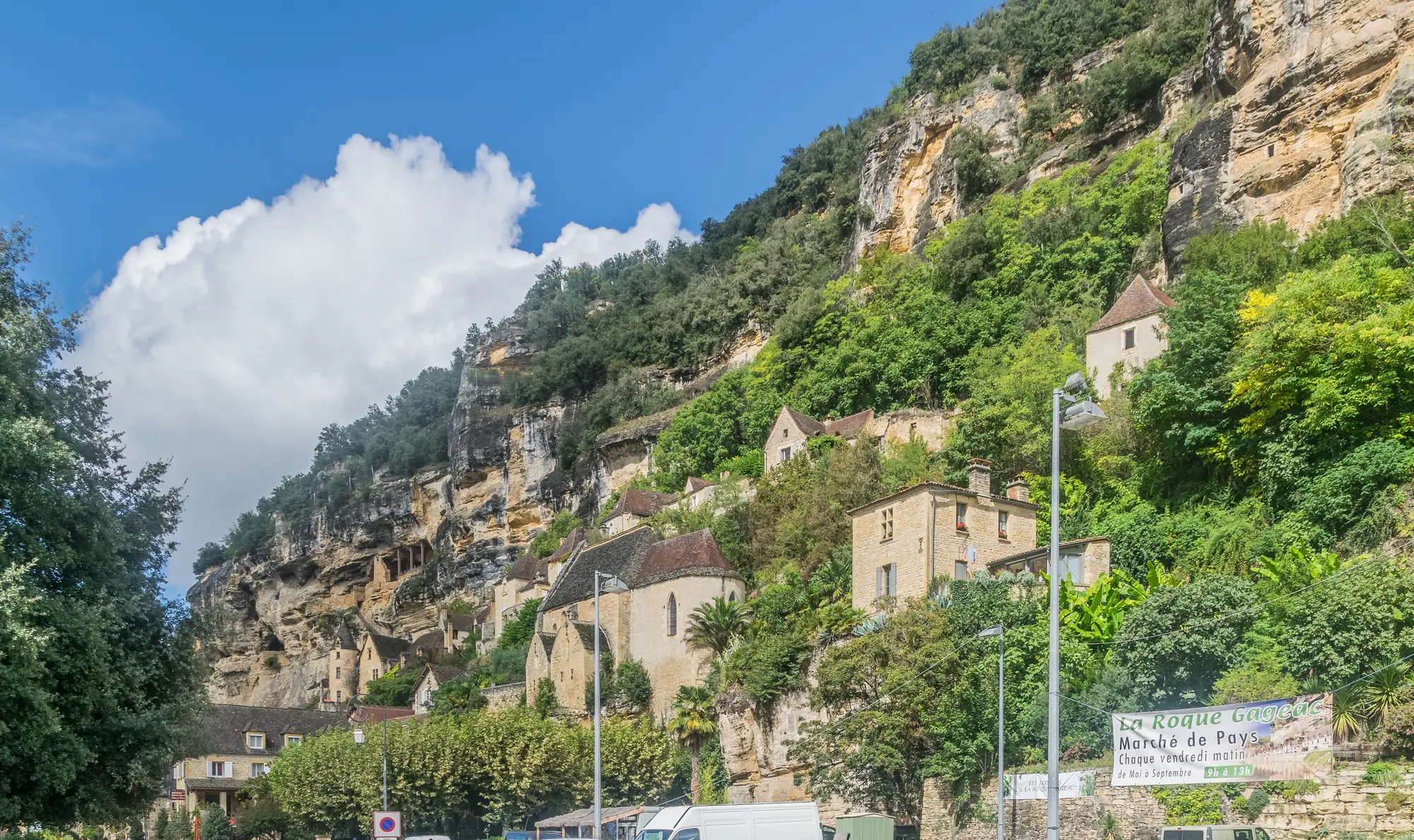 La route D703 au pied des falaises et des maisons de La Roque-Gageac, dans la vallée de la Dordogne