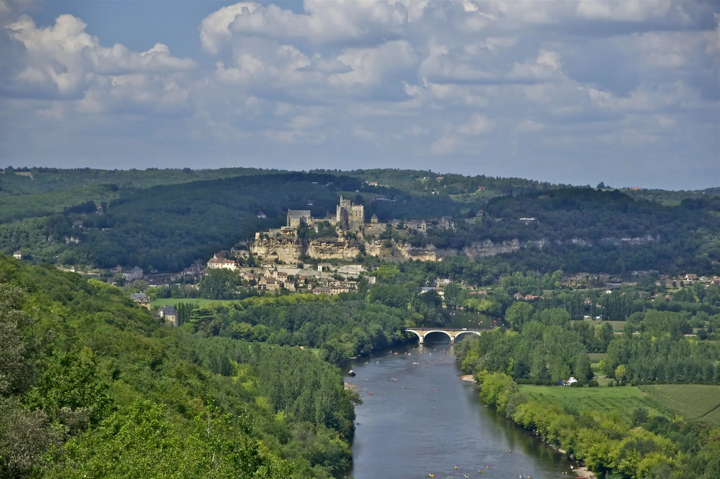 Le château et le village de Beynac au-dessus de la Dordogne semée de canoës, vus depuis Castelnaud