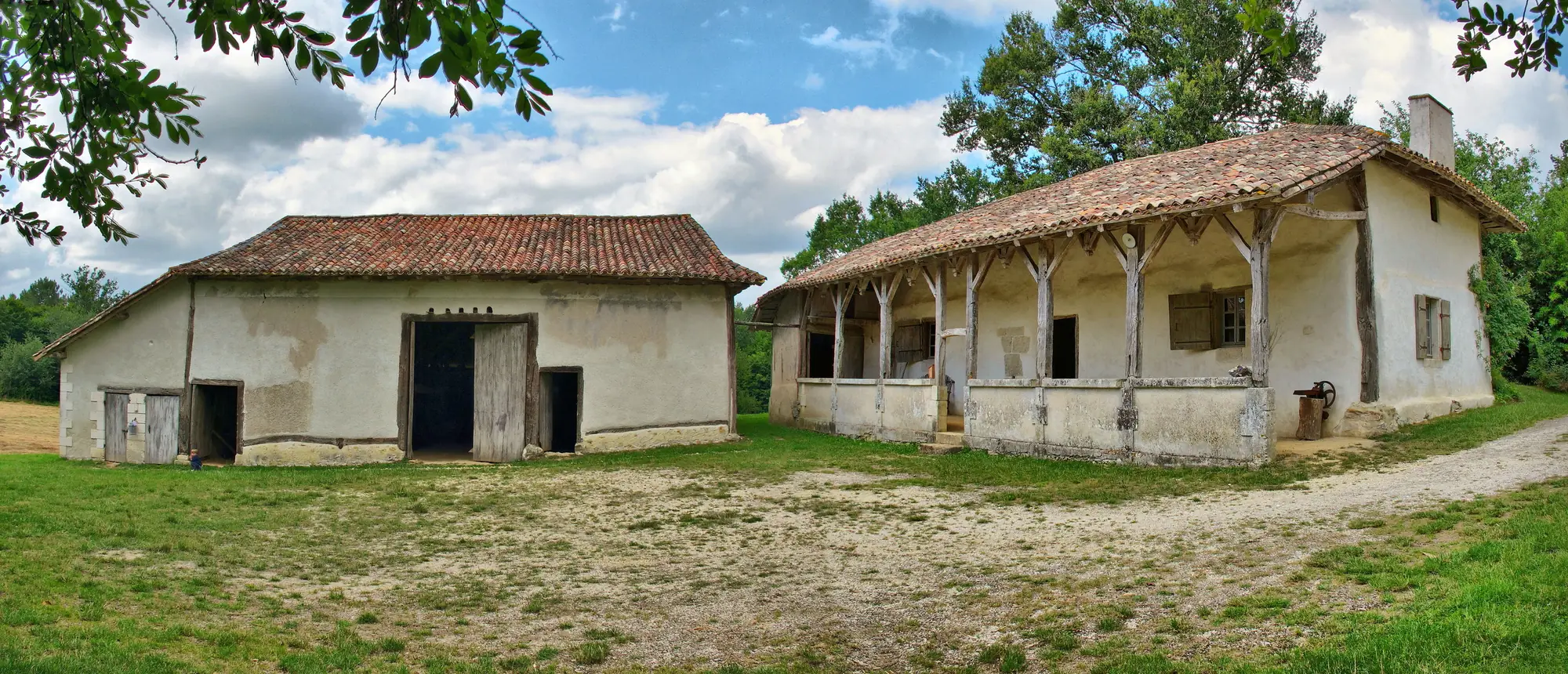 La ferme du Parcot à Échourgnac : maison en bois et torchis avec sa galerie couverte, et sa grange
