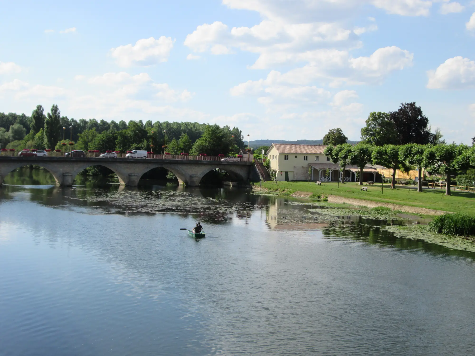 L'Isle et le pont de pierre de Mussidan depuis l'aire de Lagut, sur la véloroute, avec un canoë sur l'eau