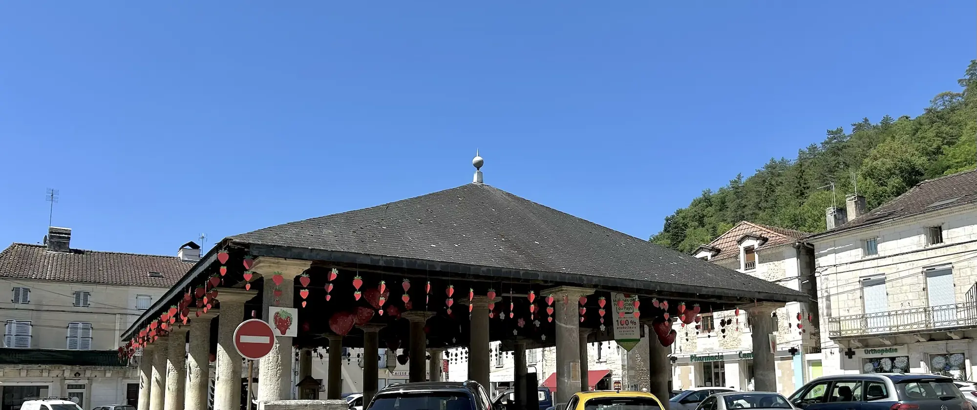 La halle de Vergt sur ses piliers de pierre, décorée de fraises